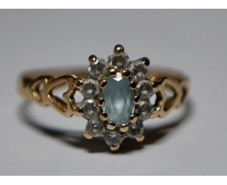 A hallmarked 9ct gold cluster ring having a central blue stone with a halo of white stones. Hallmarked for Birmingham. Size J