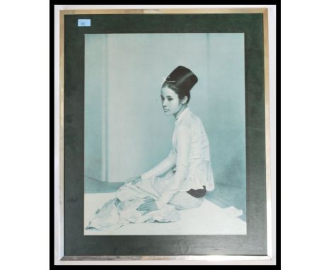 A mid century retro mounted print of a Malaysian girl in robes being signed by the artist with notation to verso ( see illust