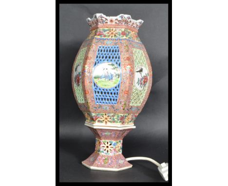 An early 20th century ceramic table lamp of lantern form having ochre red colouring with coloured sections having white carto