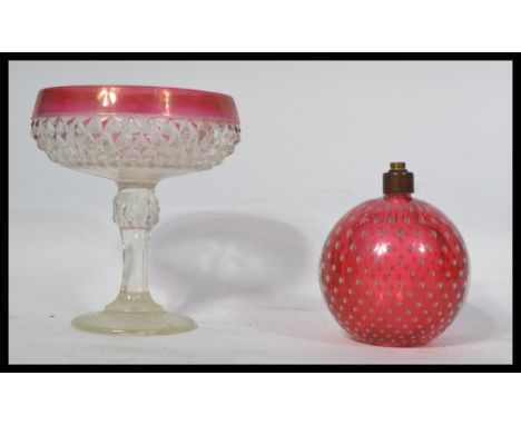 A vintage retro 20th century bubble control cranberry glass lamp base paperweight along with a cranberry glass tazza. Measure