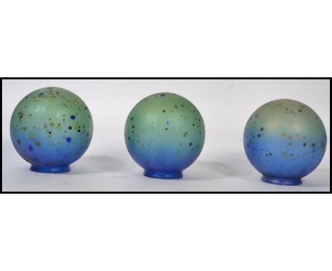 A set of 3 20th century globular loetz style irridescent glass lamp shades. Each with raised foot having stunning coloured gl