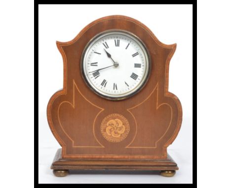 An Edwardian mahogany inlaid mantel clock being raised on brass bun feet, cylinder movement with inset French brass&nbsp; mov