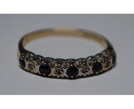 A hallmarked 9ct gold diamond and sapphire ring having alternating illusion set diamonds and blue sapphire stones. Size J.