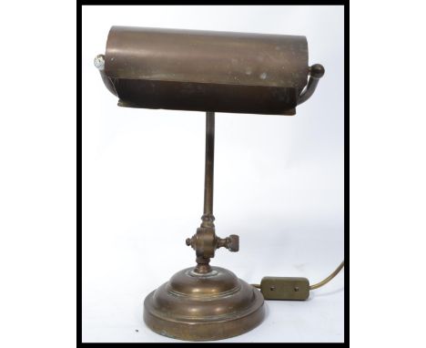 A vintage mid century brass bankers lamp raised on terraced base having angular and adjustable shade.