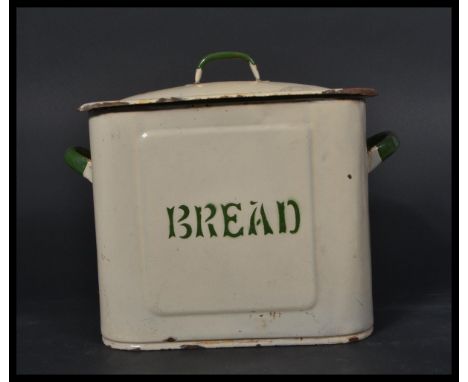 A vintage early 20th century enamel bread bin of rectangular form having a sarcophagus lid with handle atop. White ground wit