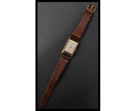 A 9ct gold Buren vintage 20th century tank style wrist watch. Dial signed Buren Grand Prix J W Benson London. The silvered di