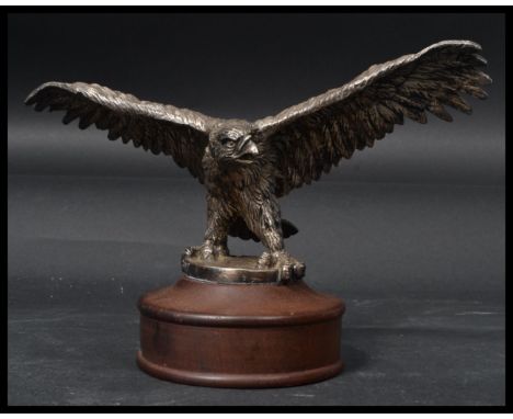 A vintage 20th century desk top paperweight in the form of a silver plated eagle raised on a wooden base. Measures 17 cm high