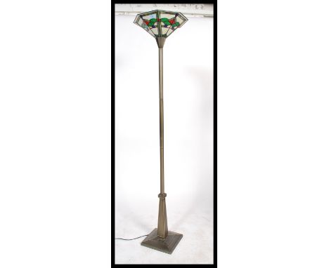 A contemporary Tiffany leaded and stained glass standard lamp uplighter. The terraced base and reeded column having brass eff