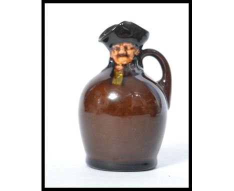 A Royal Doulton Kingsware flask flagon jug bottle having a night watchman Toby top. Marks to base.