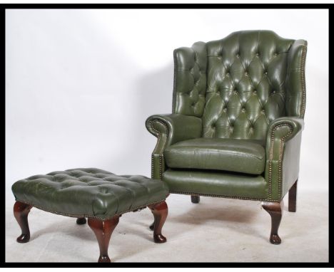 An Antique Chesterfield Style mahogany and leather button back armchair being raised on cabriole legs upholstered in green le