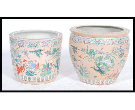 A near pair of vintage 20th century ceramic Chinese planters of large form decorated in famile rose and vert with depictions 