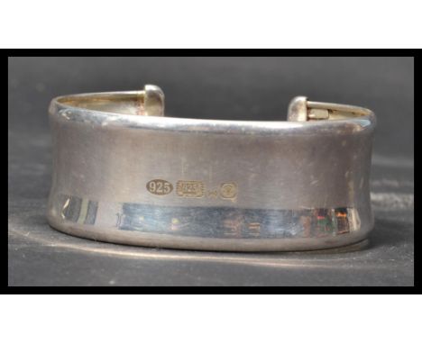 A hallmarked silver bangle bracelet of typical form having an open back with large Sheffield rose hallmarks. Weighs 26.4 gram
