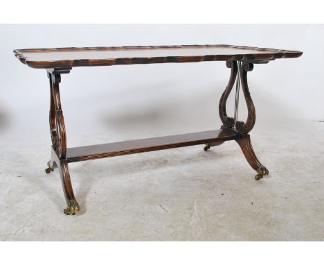 An early 20th century Regency revival Georgian style walnut coffee table raised on hairy paw feet with brass castors. Lyre / 