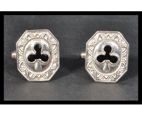 A pair of sterling silver cuff links cuffs of octagonal form having black enamel decoration of clubs.