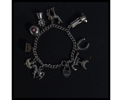 A hallmarked 925 silver charm bracelet having charms to include&nbsp; lamp, Swiss bell, stallion, deer, ships bell. Measures 