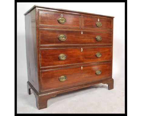 A 19th century Georgian mahogany chest of drawers having brass drop handles with brass flower back plates. The bank of two ov