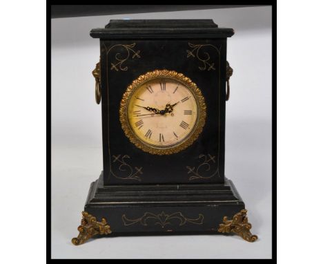 A vintage 20th century ebonised manel clock having ormulu mounts with inset clock face top centre. 39cm tall.&nbsp;