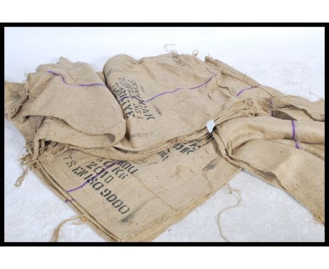 A large collection of vintage 20th century Industrial Hessian sacks, each with remains of notations. 20 in total