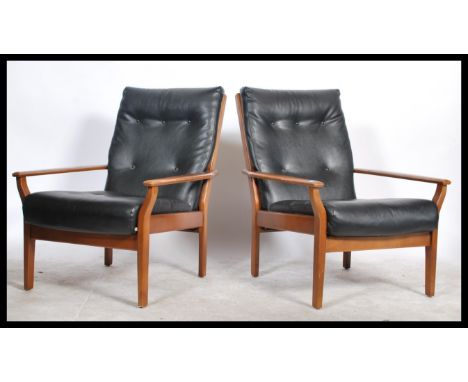 A pair of vintage / retro open framed armchairs / lounge chairs, upholstered in a black leatherette button back finish with d