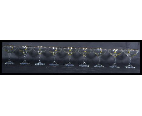 A group of 9 vintage 20th century retro 1970's Babycham glasses having shaped bowls with cylindrical stems with the yellow Ba