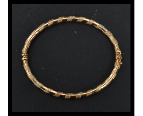 A hallmarked 9ct gold bangle bracelet having alternating half engraved bands. Weighs 4.4 grams.&nbsp;Internal diameter measur
