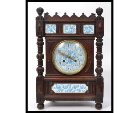 A 19th century oak cased French mantle clock having blue and white ceramic panels and face with gilt faceted hands. Turned pu