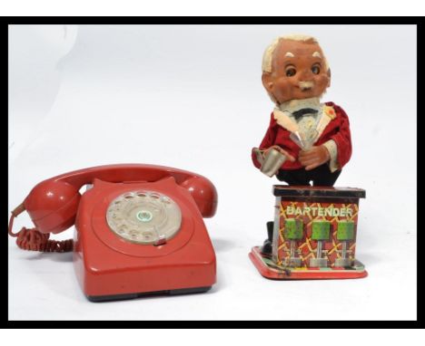 A vintage retro 20th Century battery operated tin plate figures, Bar Tender together with a retro red GPO ring dial telephone