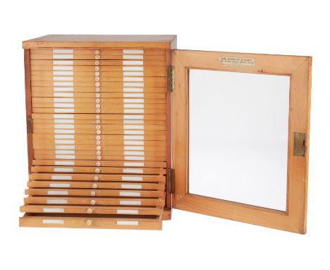 English, c.1900, French polished pine, glazed door, ceramic labels to each drawer, 29 drawers each with 3 rows, lock no key, 