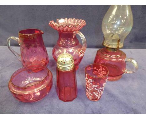 Six items of Cranberry glassware to include an oil lamp, two jugs, sugar castor, bowl and tumbler set 