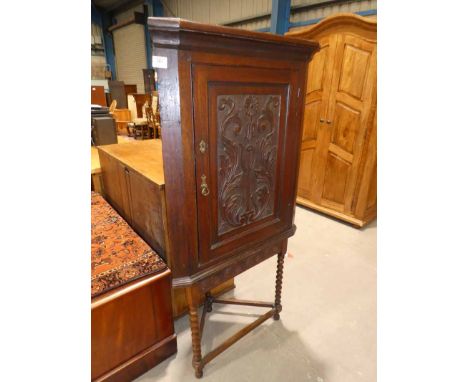 A 19th Century oak flat front corner cabinet on bobbin leg corner table support