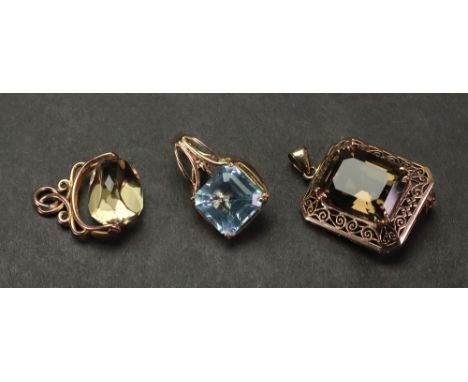 A collection of three gold and gem-set pendants comprising: a smoky quartz-set pendant brooch, the rectangular cut cornered s