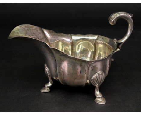 A mid 18th century style silver helmet shape sauce boat, Henry Stratford, London 1913, with lobed and fluted sides, palmette 