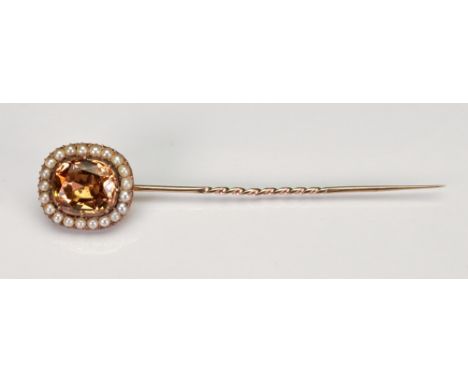 A Victorian gold stick pin, the oblong finial set with topaz within a border of pearls, 7.6g gross.