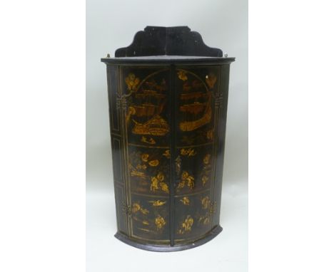 AN EARLY 19TH CENTURY LACQUERED CHINOISERIE DECORATED BOW FRONTED HANGING CORNER CUPBOARD, possibly mahogany with later paint