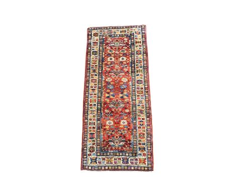 A South Caucasian runner, late 19th century, the madder field with four large polychrome medallions, starburst guls and leafy