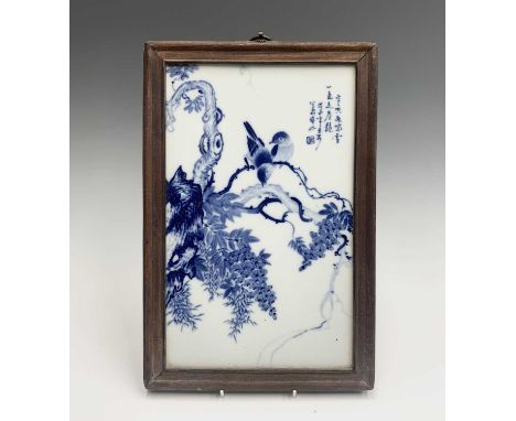 A Chinese blue and white porcelain panel, 20th century, with birds perched on a branch, script and seal, in a hardwood frame,