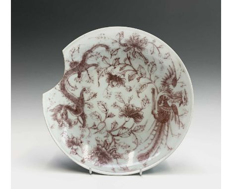 A Chinese iron-red porcelain plate, 19th century, with Daoguang mark, decorated with stylised dragon and phoenix amongst flow