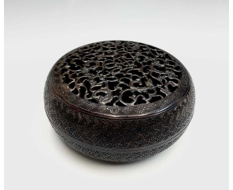 A Chinese Zitan wood circular box and cover, 18th century, the pierced cover carved with nine dragons, height 8.5cm, diameter