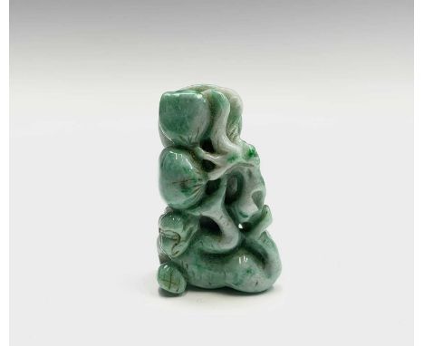 A Chinese jade figure of a monkey beneath a fruiting tree, height 4.2cm, width 2.5cm.