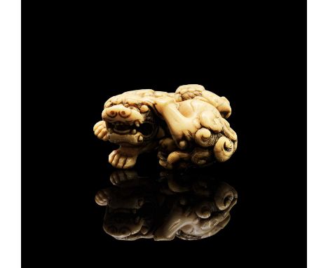 A Japanese ivory netsuke, 18th century, Kyoto school, unsigned but attributed to Tomotada, depicting a Shishi with youngster,