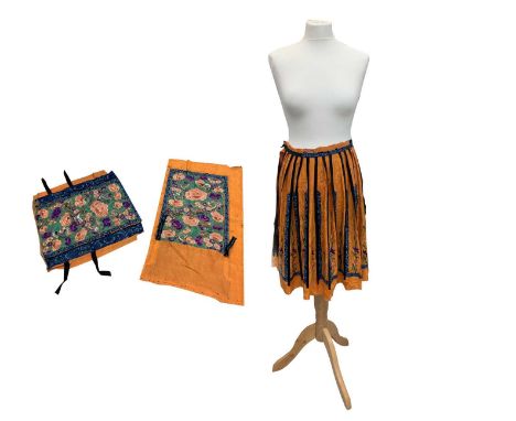 A Chinese silk embroidered skirt, Qing Period, the rows of stylised flowering plants within black borders decorated with blue