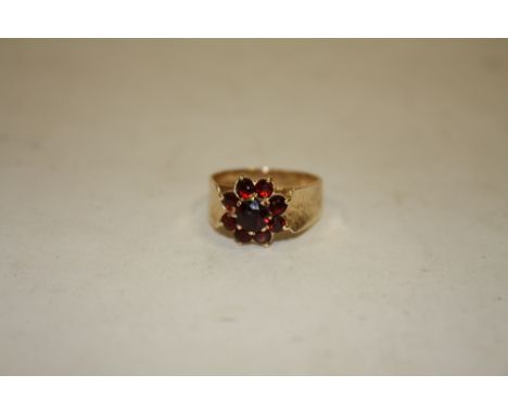 A LADIES 9CT GOLD FLORAL SET GARNET DRESS RING 