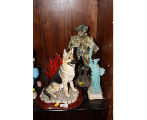 A BORDER FINE ARTS 'THE COUNTY SHOW' MT06 GERMAN SHEPHERD FIGURE ON PLINTH TOGETHER WITH TWO OTHER FIGURES AND A FLORAL CANDL