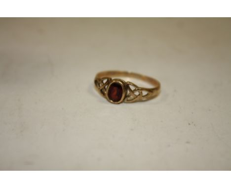 A LADIES 9CT GOLD GARNET DRESS RING IN A CELTIC STYLE SETTING 