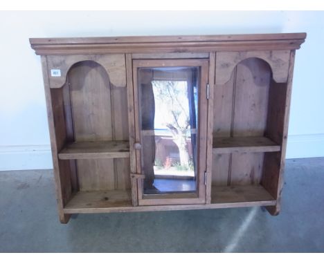 A stripped pine wall shelf with a glazed door - Height 75cm x 92cm x 19cm