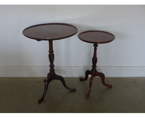 A mahogany tilt top wine table, circular top with lipped edge above tilt mechanism raised on single pedestal terminating in t