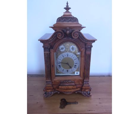 A 19th century walnut cased mantel clock of large proportions - The brass arched dial with silvered chapter ring and Roman nu