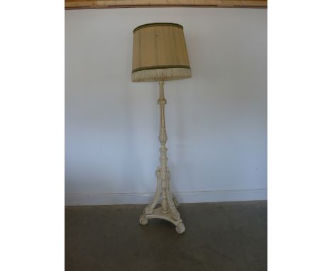 An early 20th century carved white standard lamp on swept tripod base