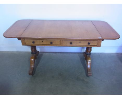 A 19th century satin sycamore and oak sofa table with two frieze drawers and opposing dummy drawers, drop flap ends on turned