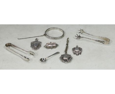 A silver hallmarked fob, vacant central shield shaped cartouche; two others similar; a pair of silver sugar bows, others EPNS